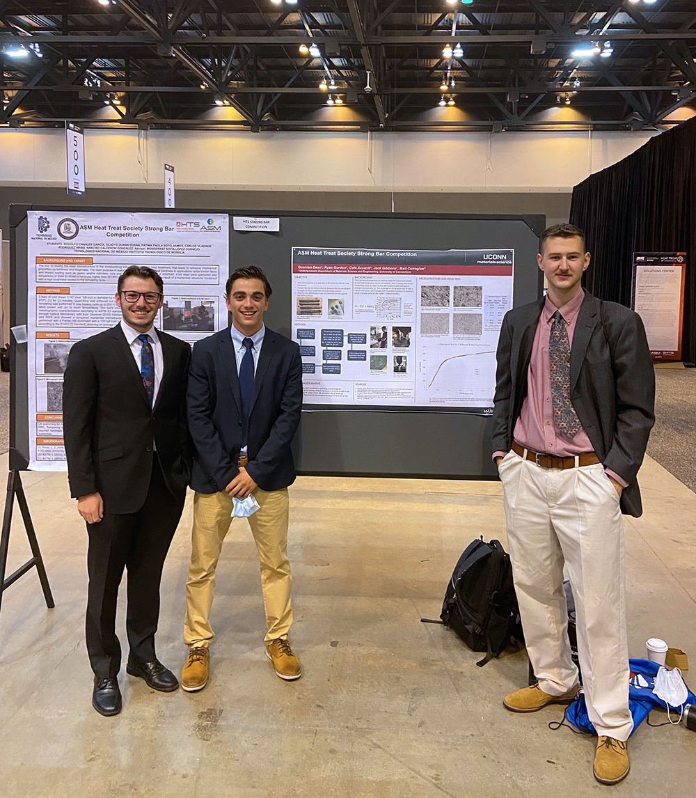 photo of Dean’s group in front of their project at the Heat Treat Society Conference. From left to right: Ryan Gordon, Cole Accord, and Quenten Dean. 