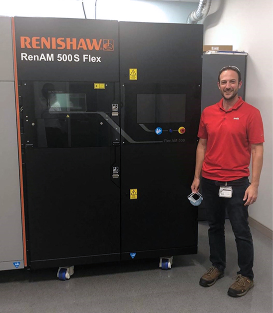 photo of Palumbo next to the Renishaw AM 500S Flex after its installation in the Mott Customer Innovation Center. 